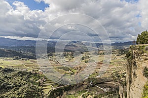 View of a valley with areas of pasture and horticultural surrounded by mountains seen from the city Ronda