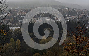 View of the valley of the river Sazava on the trees and a small town behind them under the dark clouds