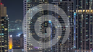 View of various skyscrapers and towers in Dubai Marina from above aerial night timelapse