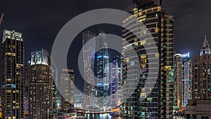 View of various skyscrapers and towers in Dubai Marina from above aerial night timelapse