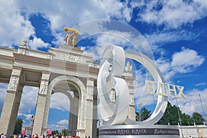 View on VDNKh entrance gate with golden sculpture and 80 years anniversary design sing in front. USSR perio