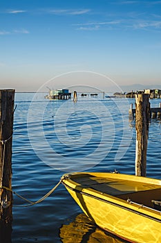 View on the Venetian lagoon with the fishermen's houses and boat, Pellestrina island, Venetian lagoon, Italy