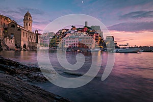 View of Vernazza one of Cinque Terre in the province of La Spezia, Italy, happy young couple picnic in the mountain with