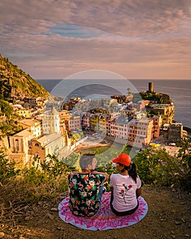 View of Vernazza one of Cinque Terre in the province of La Spezia, Italy, happy young couple picnic in the mountain with