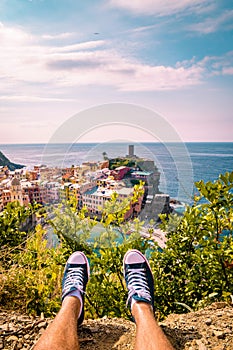 View of Vernazza one of Cinque Terre in the province of La Spezia, Italy, happy young couple picnic in the mountain with