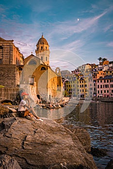 View of Vernazza one of Cinque Terre in the province of La Spezia, Italy, happy young couple picnic in the mountain with