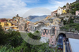 View at Vernazza village from the Railway sation with the train arrived and passengers tourists moving to the exit. Castello Doria