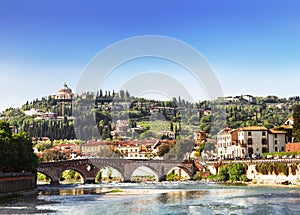 View of Verona with Ponte Pietra bridge over the Adige river and the Sanctuary of our lady of Lourdes on a hill,