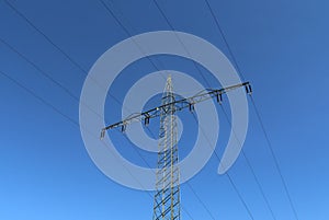 View of very large electricity pylons with high voltage cables from a moving car