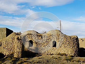 View of a very old stone house with thatched roof and ancient windows