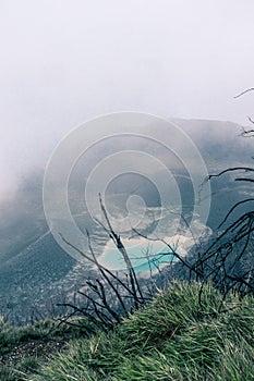 View of the viewpoint of the Turrialba Volcano National Park where you can see a turquoise volcanic lagoon on a foggy day near the photo