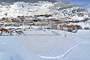 View of the village from an alpine skiing slope in winter day