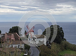 View on village Bretanha with old windmill called Red Peak Mill, Moinho do pico vermelho sea and clouds background, Sao photo