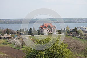 View of the village house through the drooping willow branches.