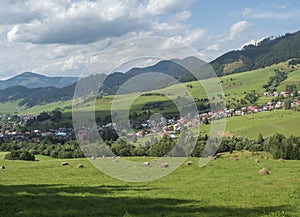 view on village Liptovska Luzna at the foothills of Low Tatras mountains with lush green meadow, forested hills and