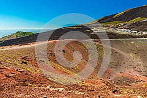 View of a volcanic crater with colorful lava sand and stones. Panoramic view of Mount Etna, Sicily, Italy