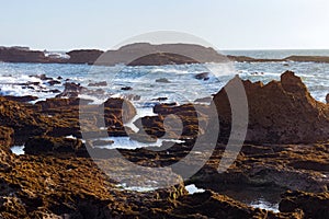 View of the volcanic shore of the Atlantic Ocean in the area of the city of Essaouira in Morocco on a sunny summer day