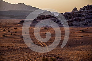 View of the Wadi-Rum desert in JordaniÃ©, with its erratic high mountains and the red-golden sand at sunset.