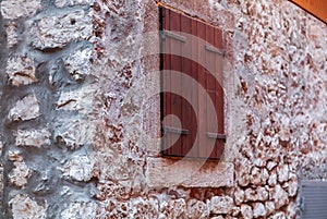 View of wall of coarse stone and close wooden window FOCUS ON C