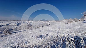 View of waste heaps covered in snow under a blue sky in Donbas, Ukraine photo