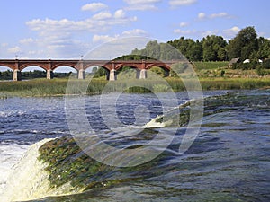 View from the waterfall to the ancient arched brick bridge photo