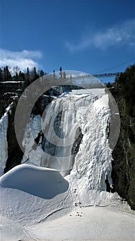 view of a waterfall under a beautiful winter day in Quebec Canada