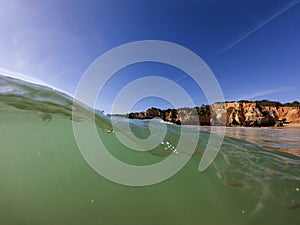 View of a wave breaking at the beautiful Alemao Beach in Portimao photo
