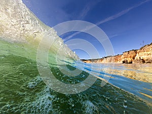 View of a waver breaking at the beautiful Alemao Beach in Portimao, Algarve