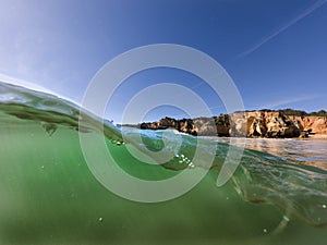 View of a waver breaking at the beautiful Alemao Beach in Portimao, Algarve