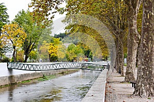 View of a wavy bridge over the river in Leiria city park at fall