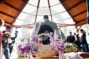 A view on the wedding couple standing in the restaurant from behind. Glasses with champagne stand on the table