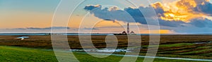 View of the Westerheversand Lighthouse with coastal salt marsh at Westerhever by high tide in winter, Nordfriesland, German state