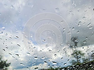 View from wet car window on rainy spring clouds