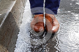 View on wet shoes standing near hailstones after hailstorm