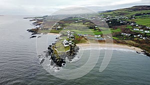 View of the white bay of the River Foyle in Inishowen with urban houses on the rocky shoreline