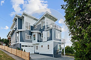 View of a white and blue home with nice outdoor landscape