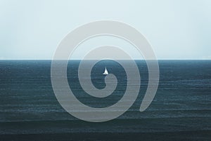 View of a white boat sailing in the blue ocean before the horizon