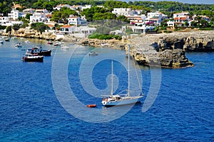 View on white boats, the beach and village Alcaufar on Menorca