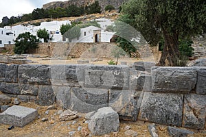 View of the white buildings of Captains houses of the 16th-18th centuries and the ancient Acropolis of Lindos in August.