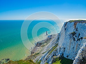 View of the white chalk headland cliffs and Beachy Head Lighthouse in the Seven Sisters National park, Eastbourne, England.