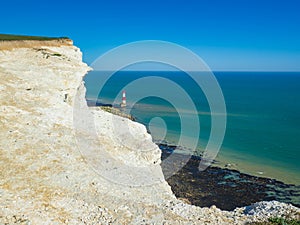 View of the white chalk headland cliffs and Beachy Head Lighthouse in the Seven Sisters National park, Eastbourne, England.
