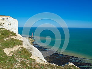 View of the white chalk headland cliffs and Beachy Head Lighthouse in the Seven Sisters National park, Eastbourne, England.