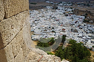 View of the white houses of the 16th-18th centuries from the ancient Acropolis of Lindos in August. Rhodes, Dodecanese, Greece.