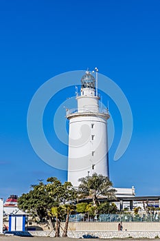 View of a white lighthouse in the port of Malaga