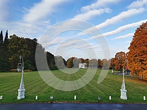 View of  a white lion sculpture, an oil meadow, a beautiful lantern, a pavilion and autumn leaf trees in the park