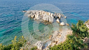 View of white rocks in the blue sea from Kassiopi shoreline, Corfu, Greece