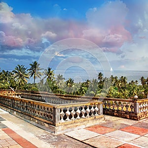 View of a white sailboat from the terrace on the ocean coast