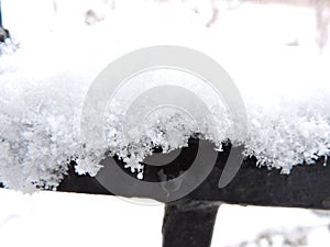 View of  white snow on metal fence