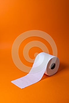 View of a white toilet paper roll over an orange background photo