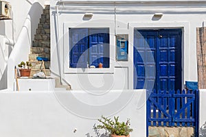 View of the white villa with blue doors and shutters. Folegandros Island, Greece